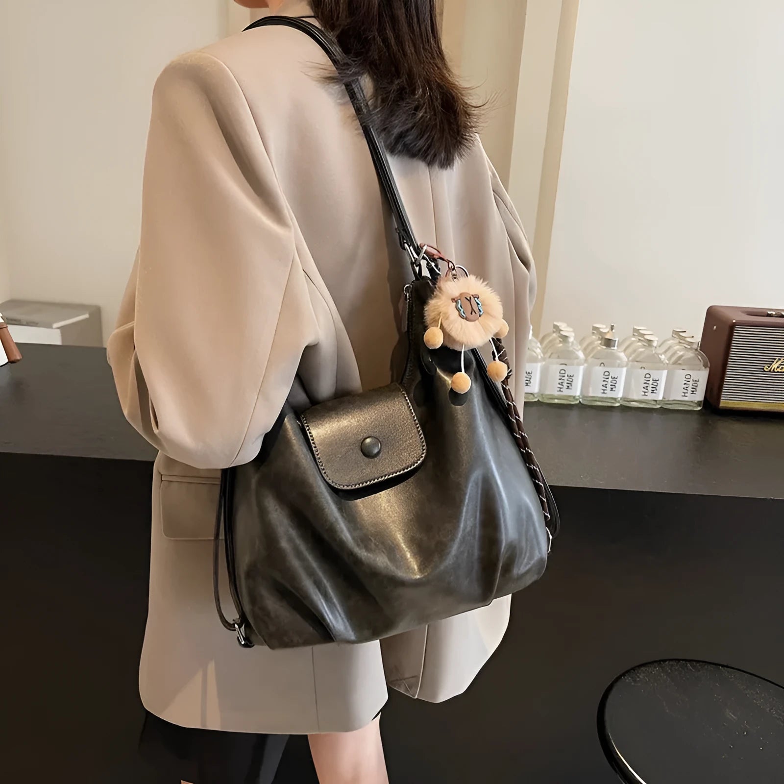 Women's textured PU leather shoulder bag with single strap and mobile phone compartment in black colour