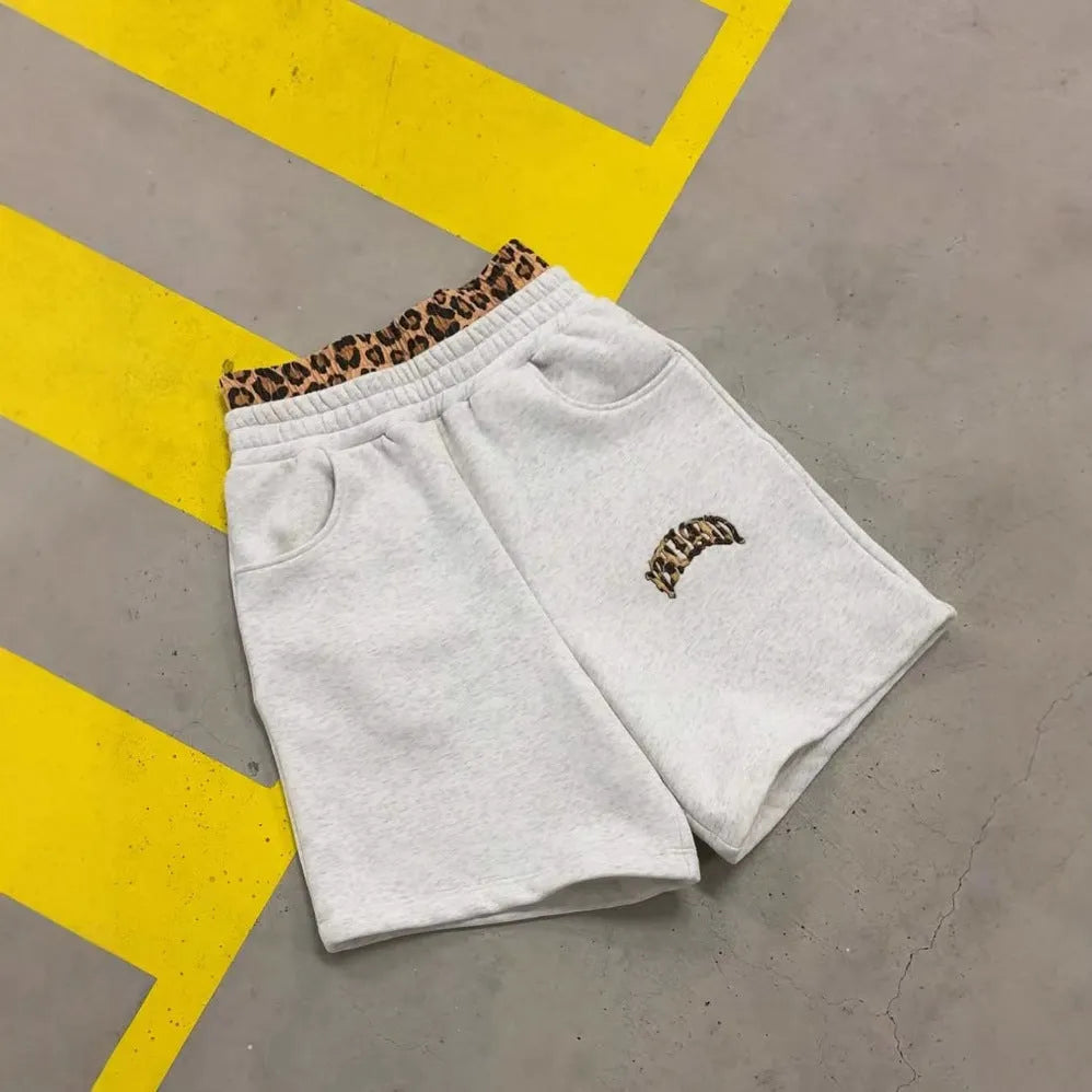 Men's loose grey patchwork double waist hip hop trousers on a plain background