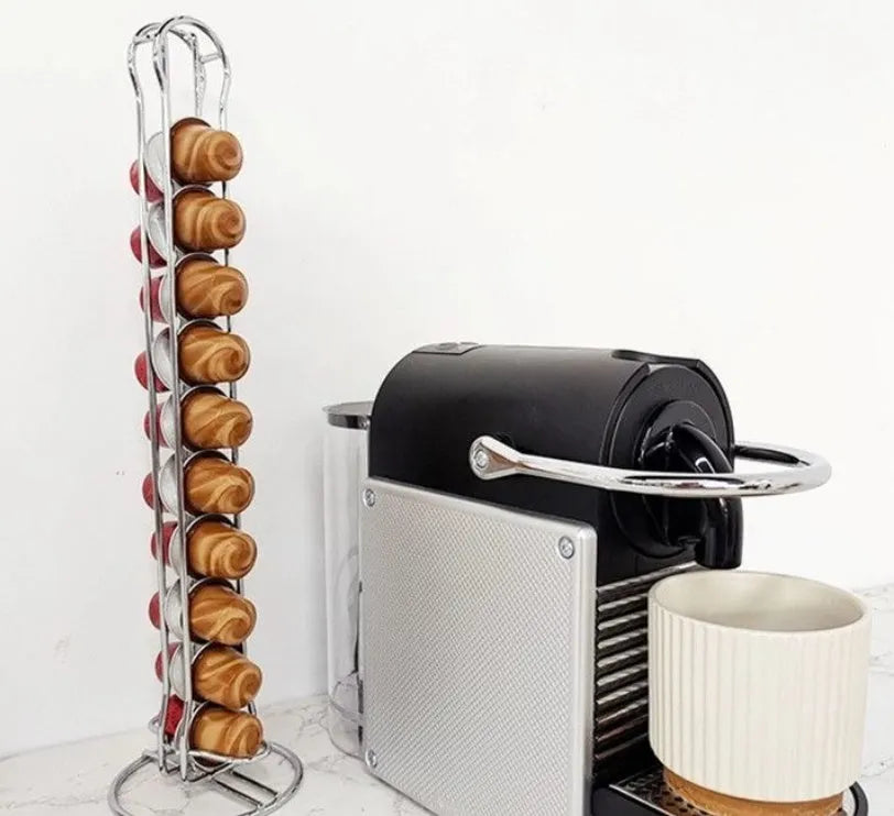 Black wrought iron coffee capsule storage rack holding pods on two shelves.