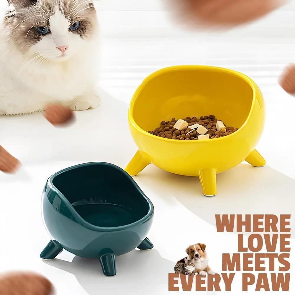 Green ceramic cat food bowl with four-leg stability base on wooden floor