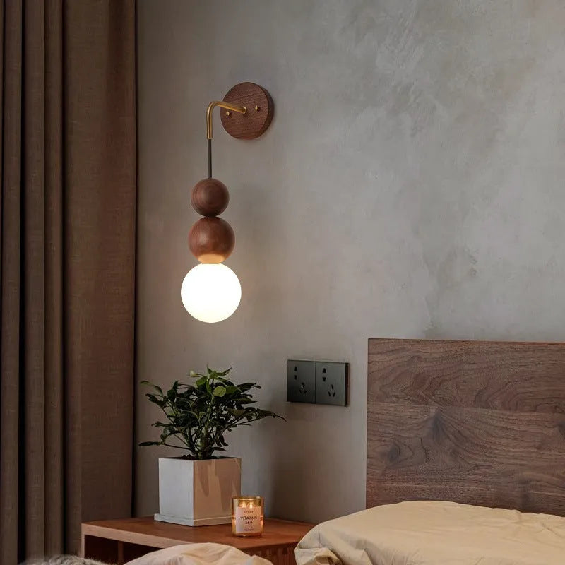 Walnut and copper suspension wall lamp with tri-colour light on a wall