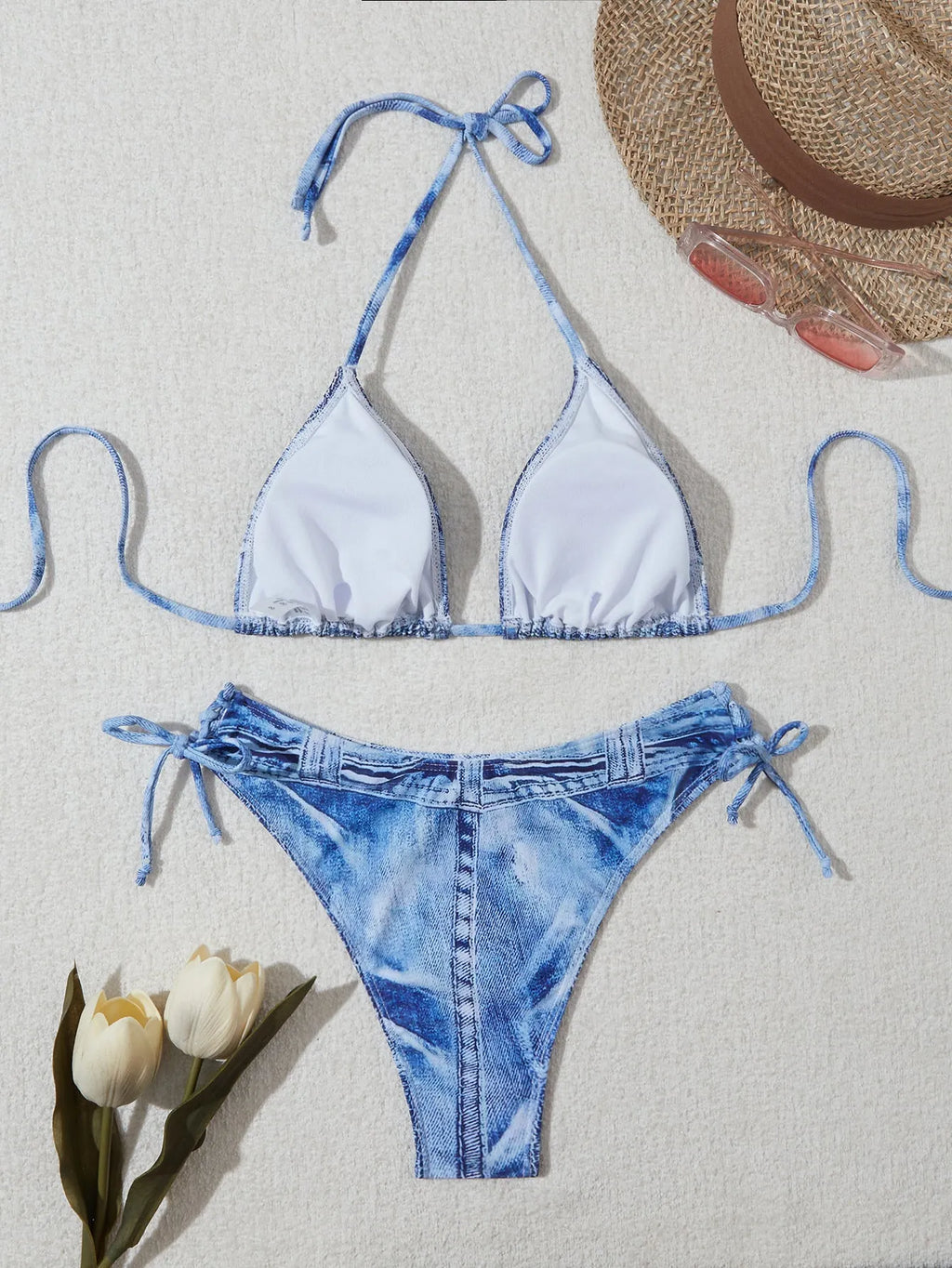 Women's denim blue printed bikini swimsuit with strap design on a hanger