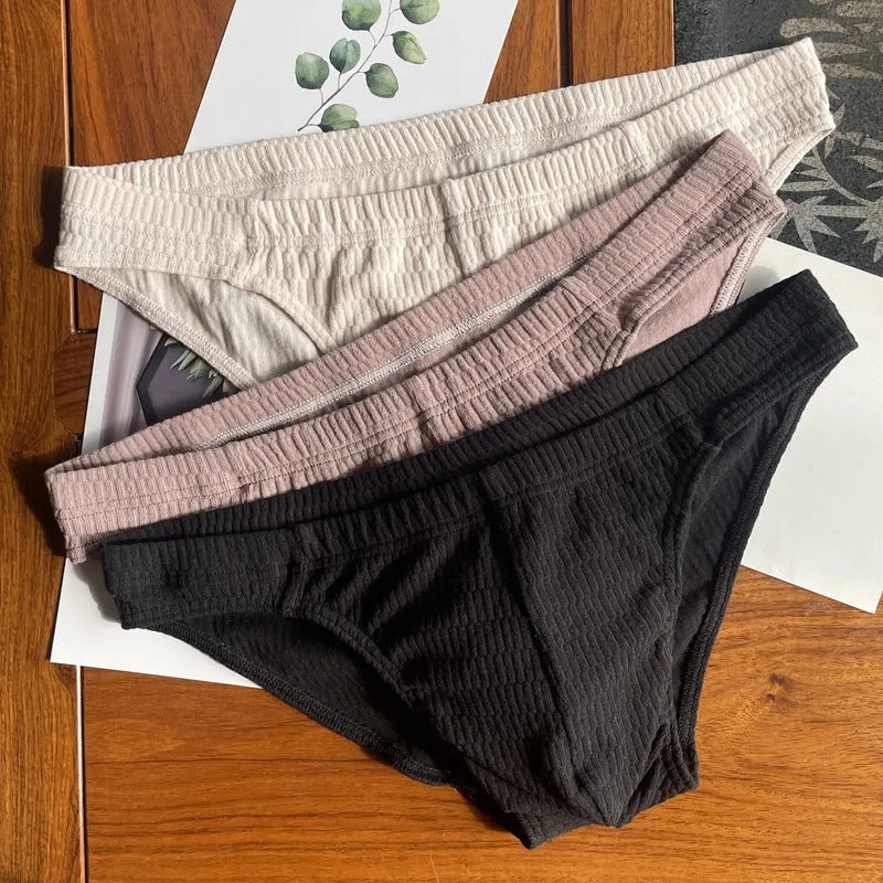 Men's solid colour cotton triangle briefs with a mid-waist waistband on a white background.