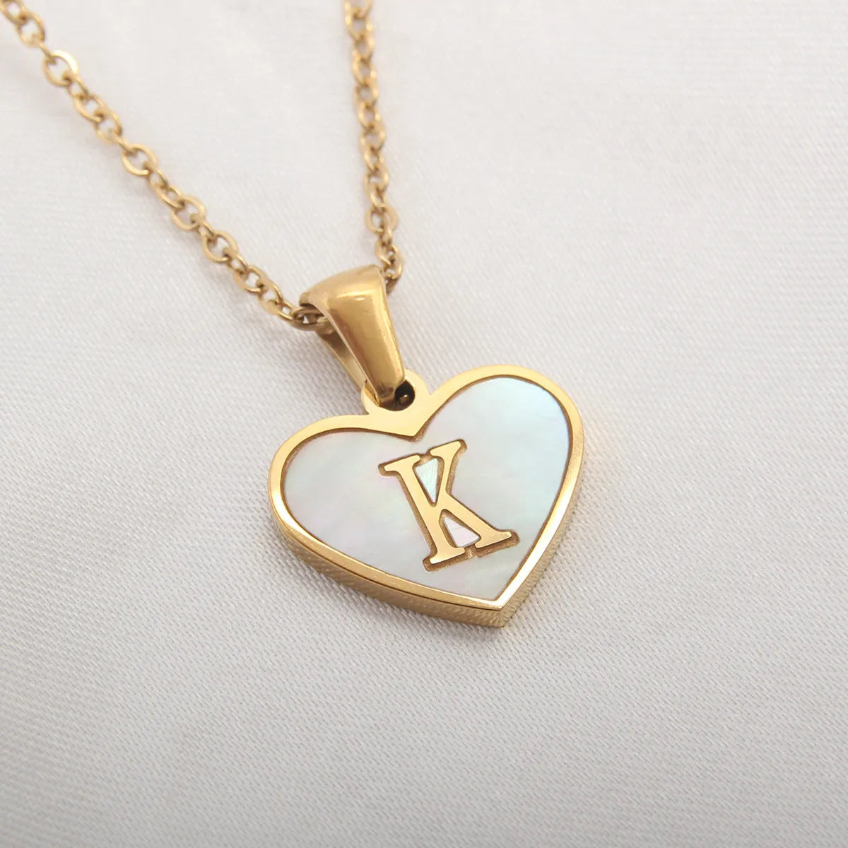 Gold plated heart-shaped personalised necklace with white shell charm on an adjustable chain.