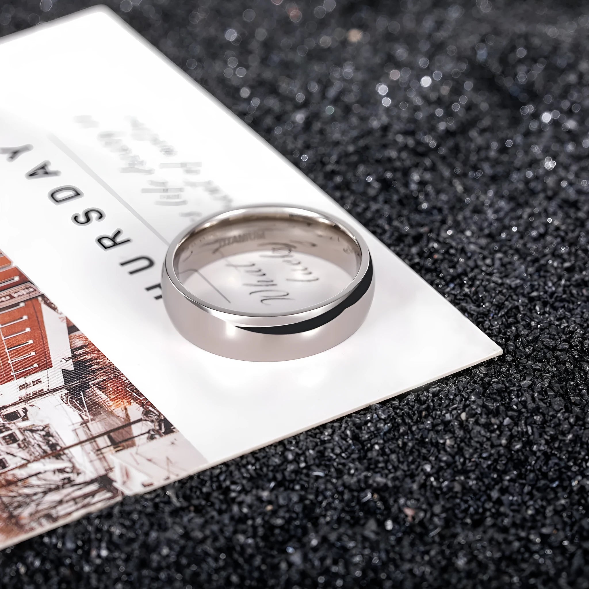 A silver-coloured titanium steel ring shown in a minimalist style on a grey background.