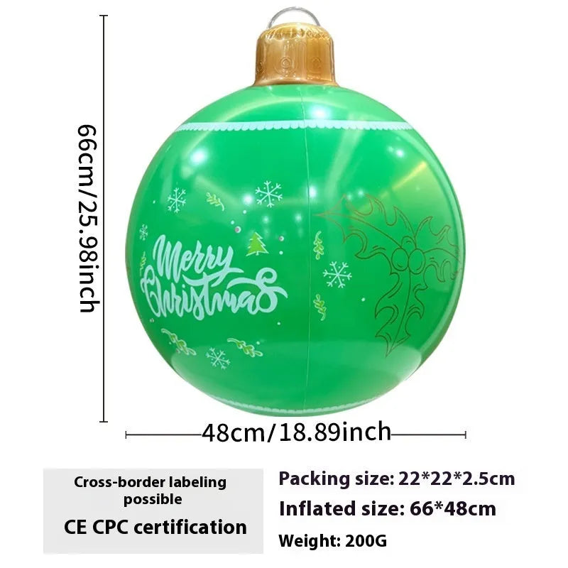 Large red inflatable Christmas ball with snowflake pattern and flash light, shown with a hand pump in a garden setting.