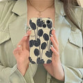 Black silicone phone case with a tulip floral pattern for iPhone.