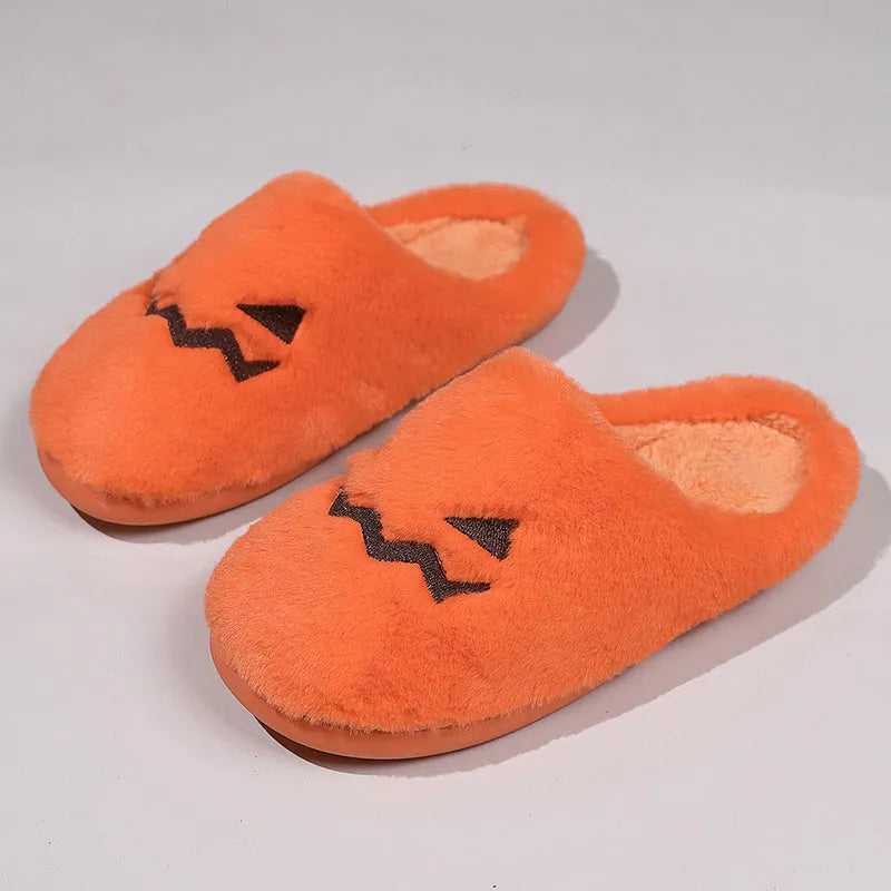 Orange Halloween pumpkin themed slippers with coral velvet upper and plush lining on a flat PVC sole.