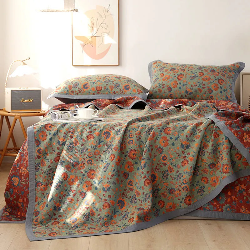 Three-piece cotton gauze bed blanket set with floral botanical pattern, shown with pillowcases.