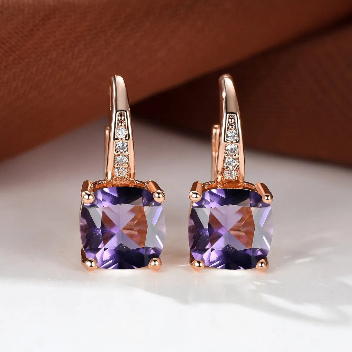 Square geometric ear hook earrings with zircon stones in an electroplated copper setting.