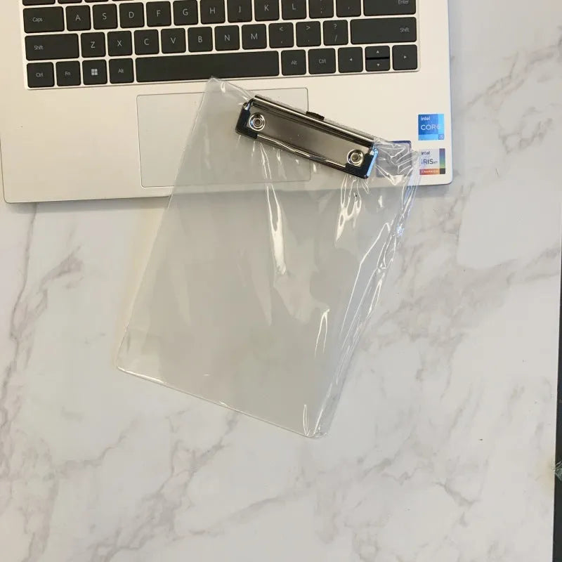 A4 transparent plastic writing board pad with metal clip in blue colour on a desk
