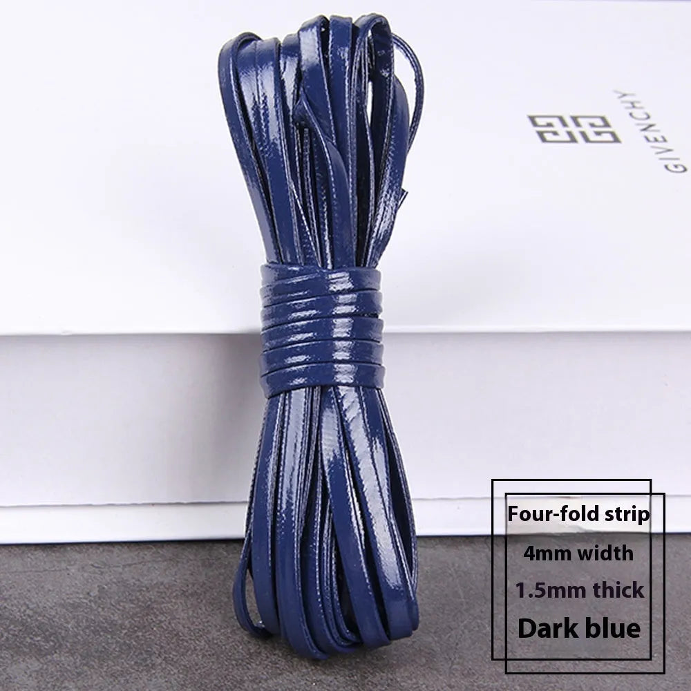 Spools of black, brown, and blue PU leather crafting cord in different widths on a craft table.