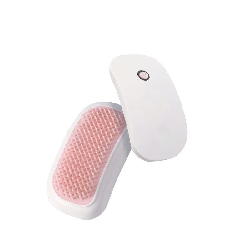 Pink handheld electric pet grooming massage brush with TPE teeth on a white background.