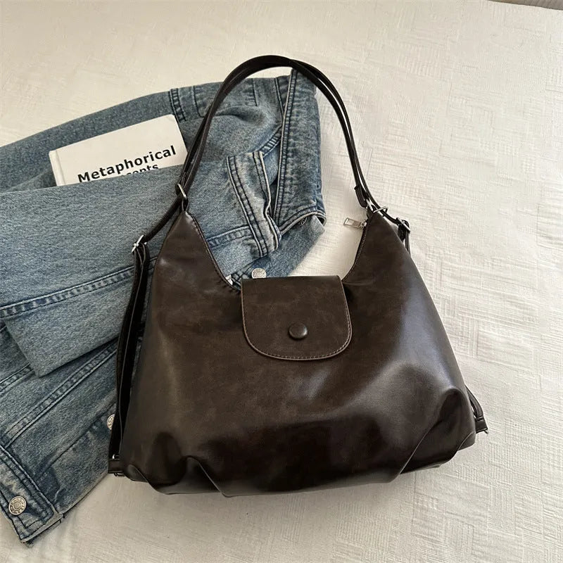 Women's textured PU leather shoulder bag with single strap and mobile phone compartment in black colour