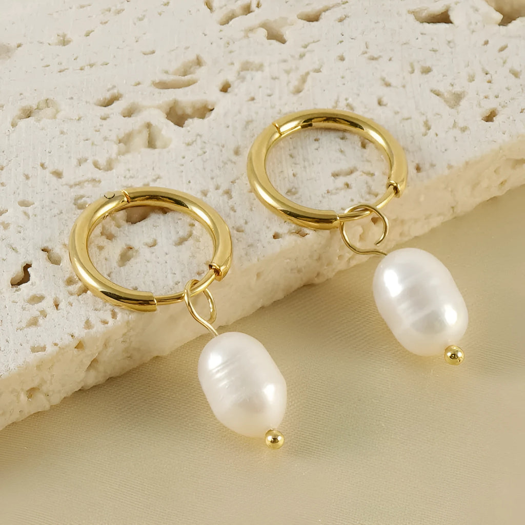 A pair of gold geometric earrings with a pearl detail on a stainless steel post.