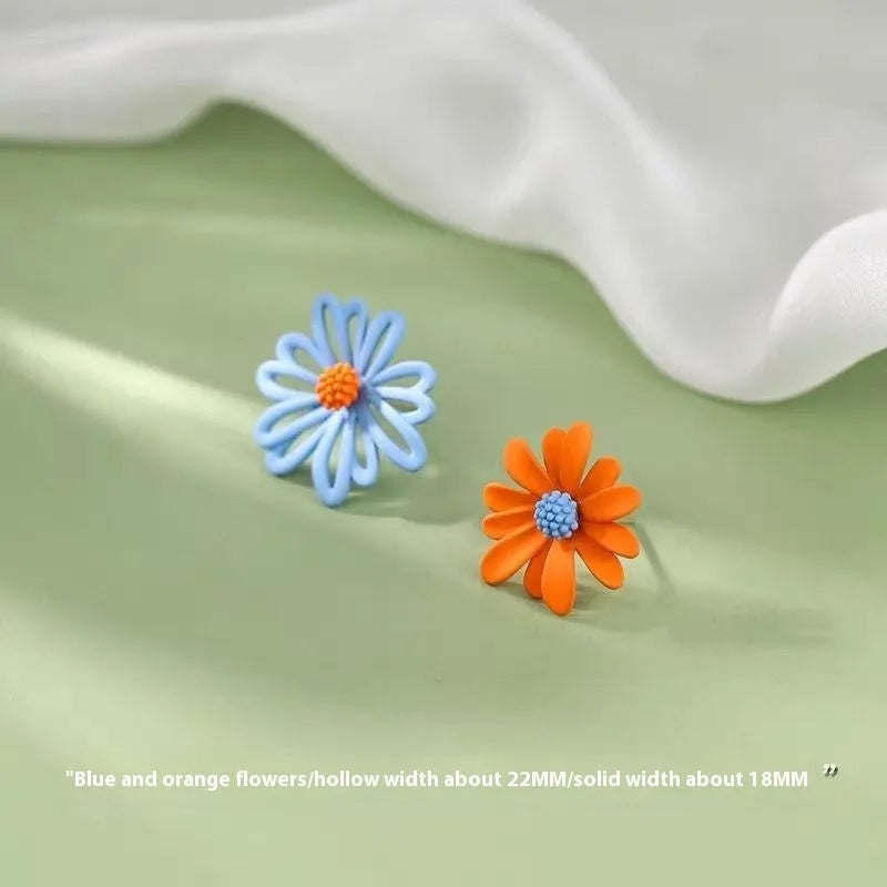 A pair of cartoon-style flower stud earrings in alloy, shown in a two-tone colour option.