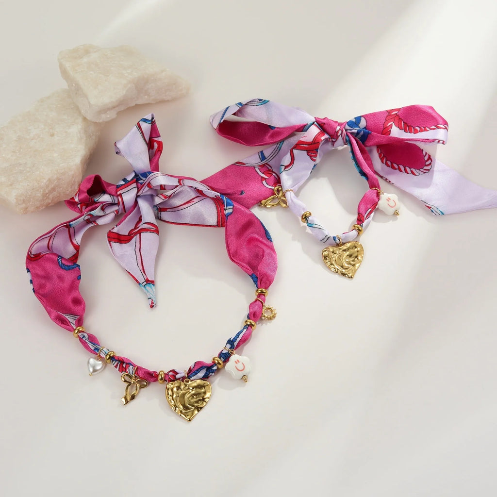 Gold-plated geometric love pendant necklace and matching bracelet jewellery set on display