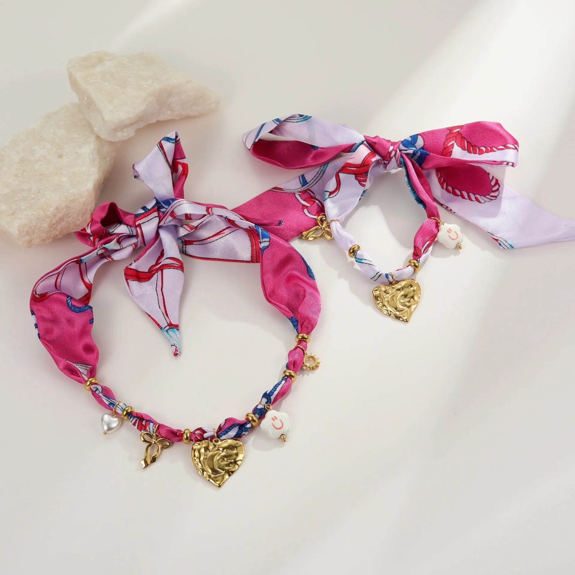 Gold-plated geometric love pendant necklace and matching bracelet jewellery set on display