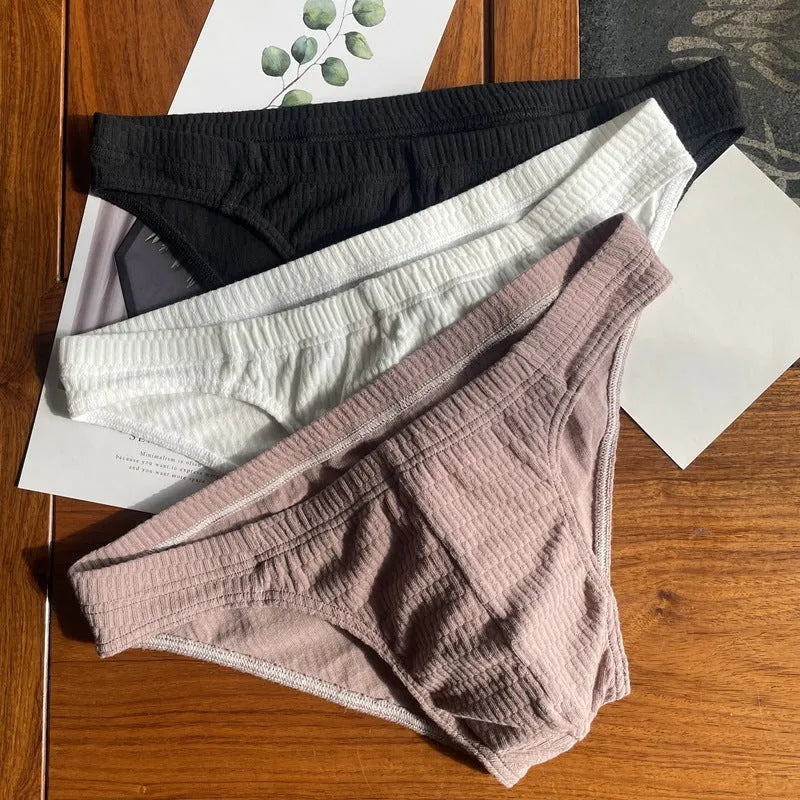 Men's solid colour cotton triangle briefs with a mid-waist waistband on a white background.