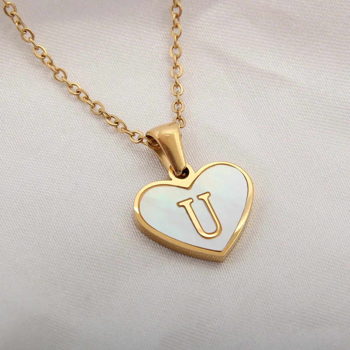 Gold plated heart-shaped personalised necklace with white shell charm on an adjustable chain.