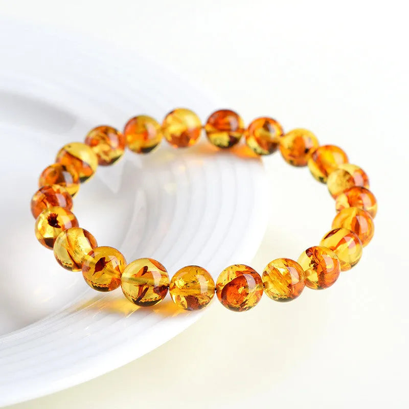 Natural yellow piebald amber bracelet with geometric design and polished Baltic amber beads