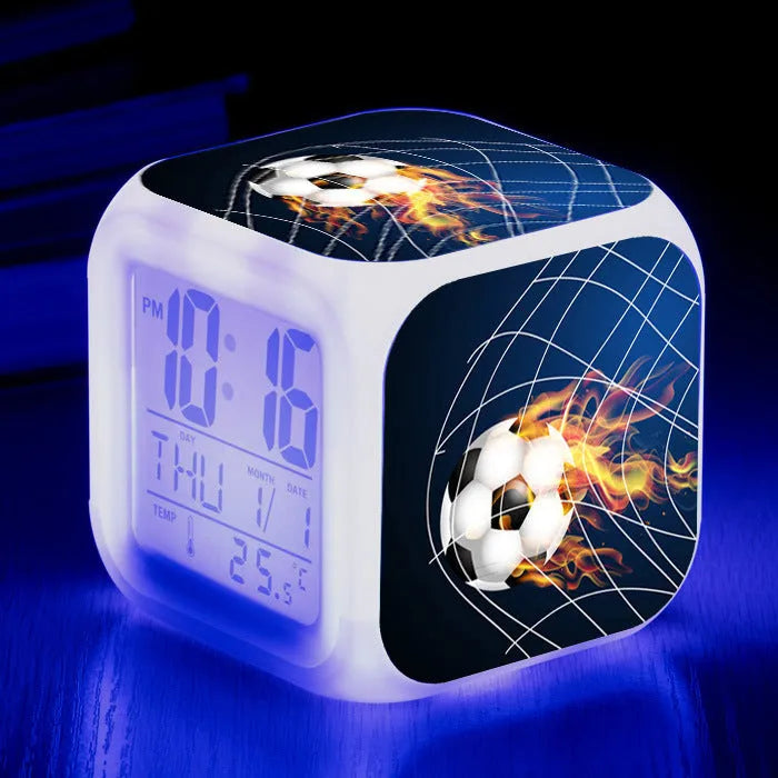 Square plastic alarm clock with football pattern design showing four alarm settings and USB charging port