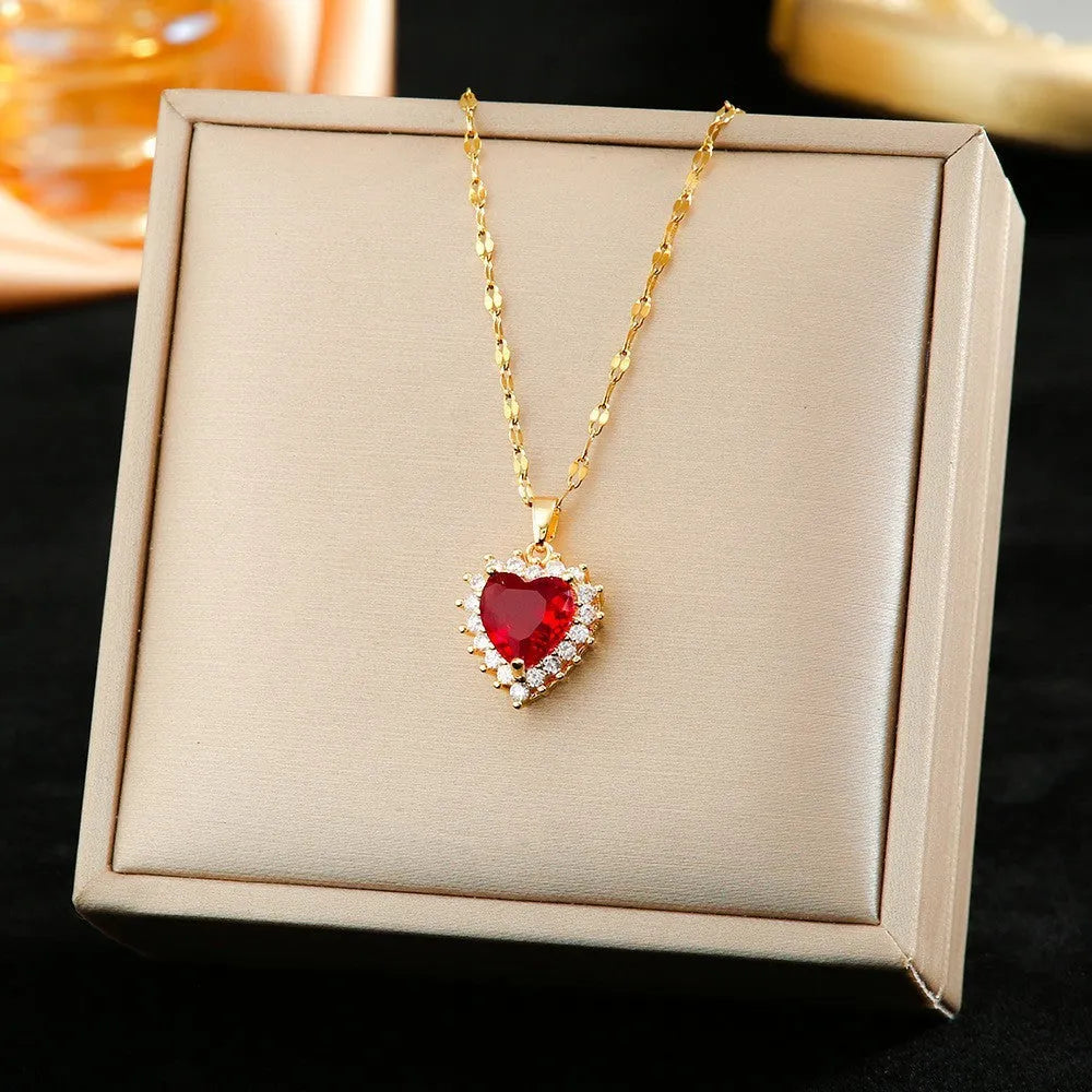 Gold red titanium steel jewellery set with heart flower pendant, matching earrings, and ring on a water wave chain.