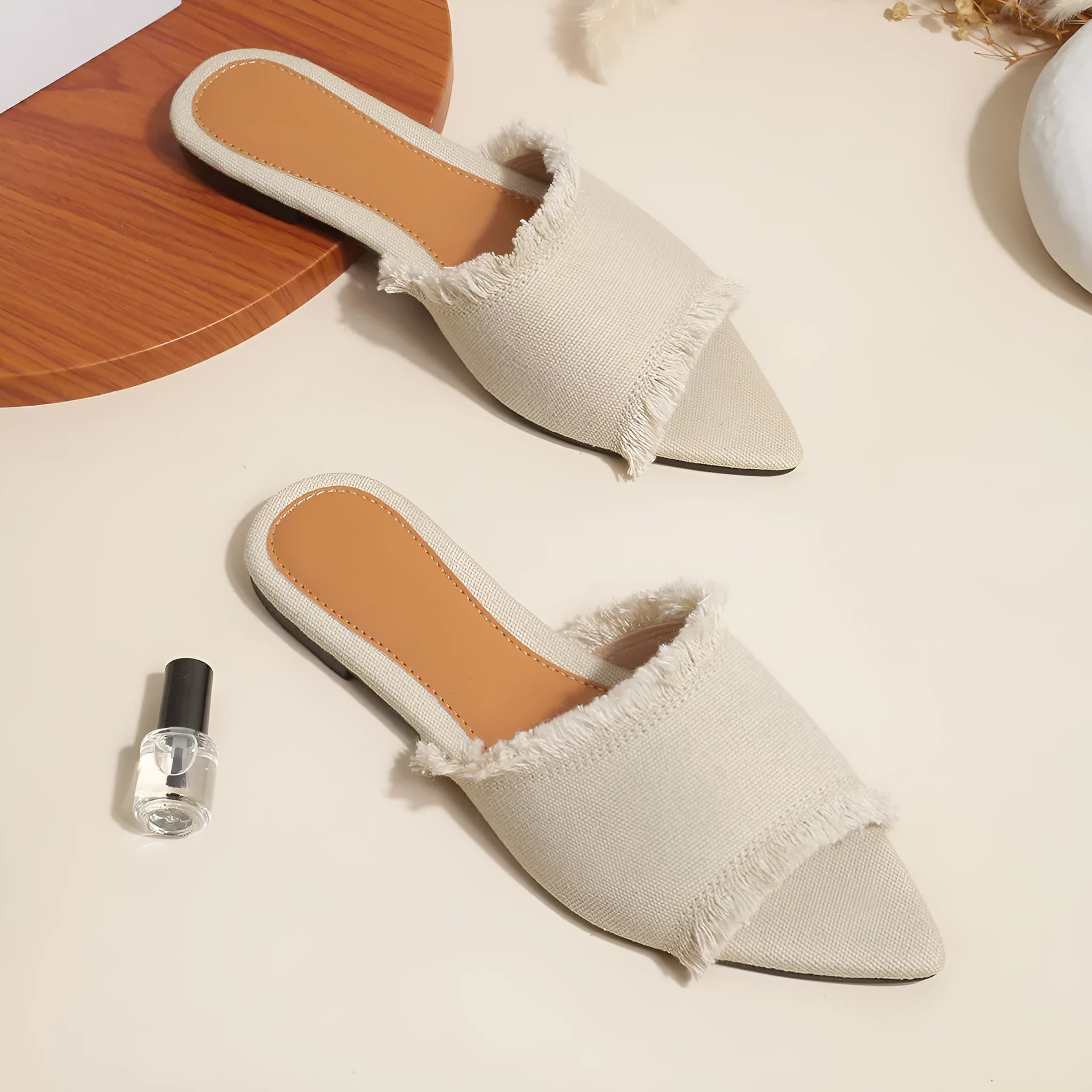 Women's flat denim slippers with tassel detail in apricot colour on a white background