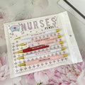 Five nurse-themed retractable ballpoint pens laid out, showing humorous medical designs.