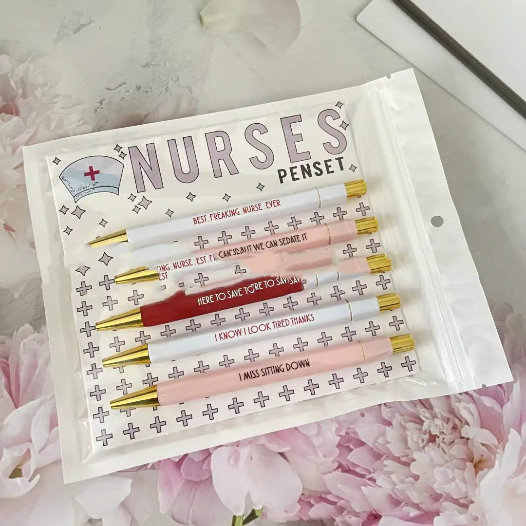 Five nurse-themed retractable ballpoint pens laid out, showing humorous medical designs.