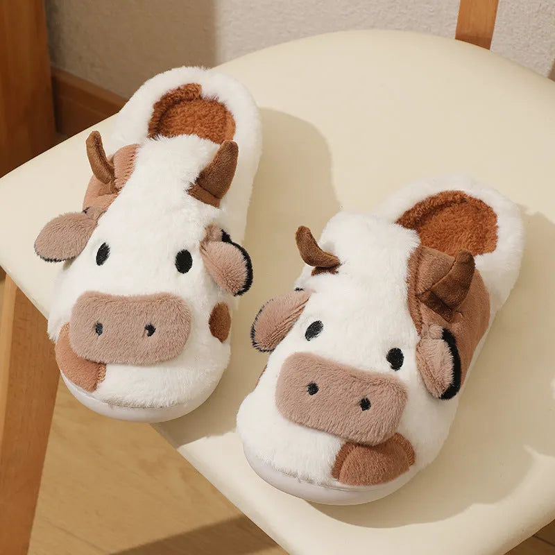 White plush cow slippers for women with a non-slip textured sole.