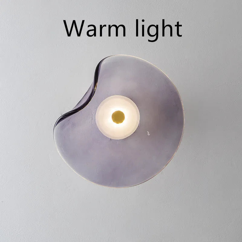 Round glass wall lamp for bedroom bedside in cognac, grey or light colour finishes.