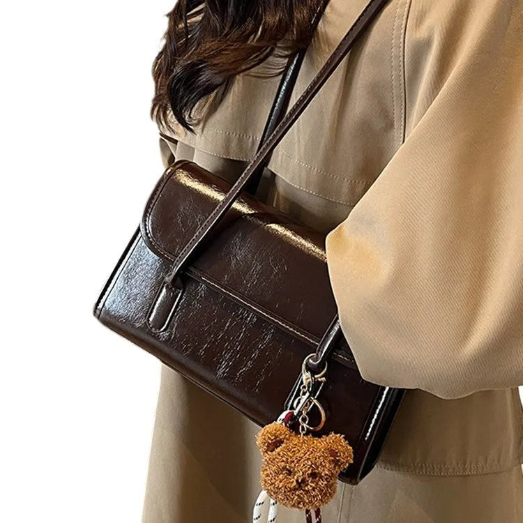 Brown women's PU leather shoulder bag with square shape, pendant detail, and double shoulder straps
