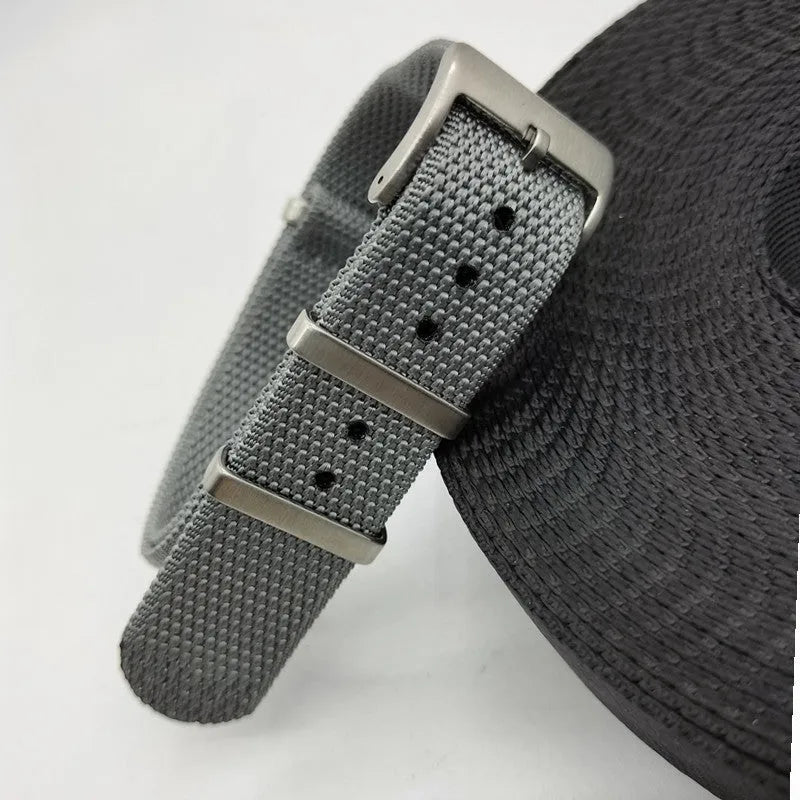 Nylon quick-release watch strap in army green, showing the integrated spring bar mechanism.