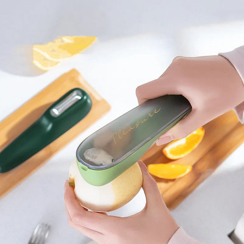 Dark green kitchen peeler with a stainless steel blade extended from its storage tube, showing the non-slip handle.