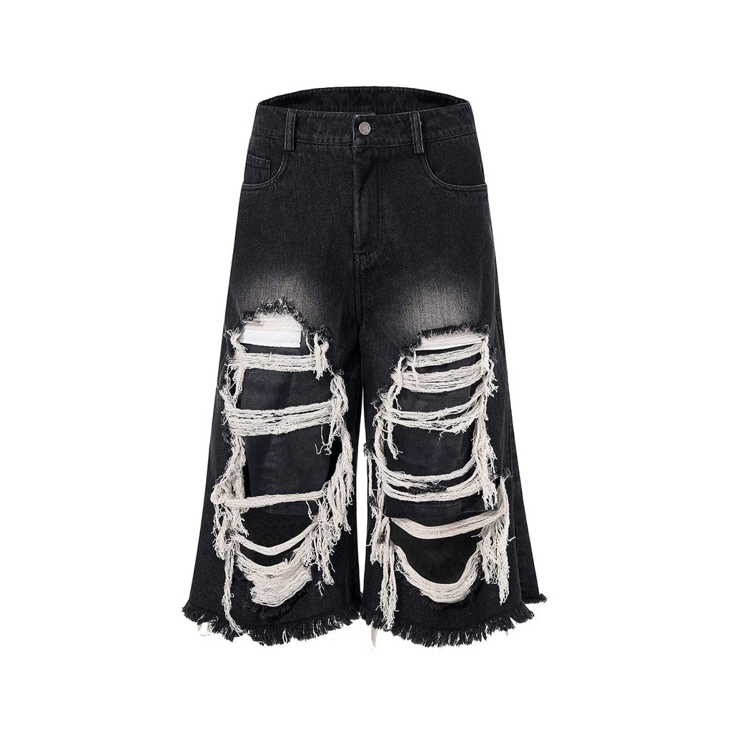 Black cropped wide-leg jeans with ripped patch detail on the leg, showing a mid-high waist and loose fit.