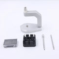 Silver tool steel multi-purpose press strap removal tool for watches and electronics on a workshop surface.
