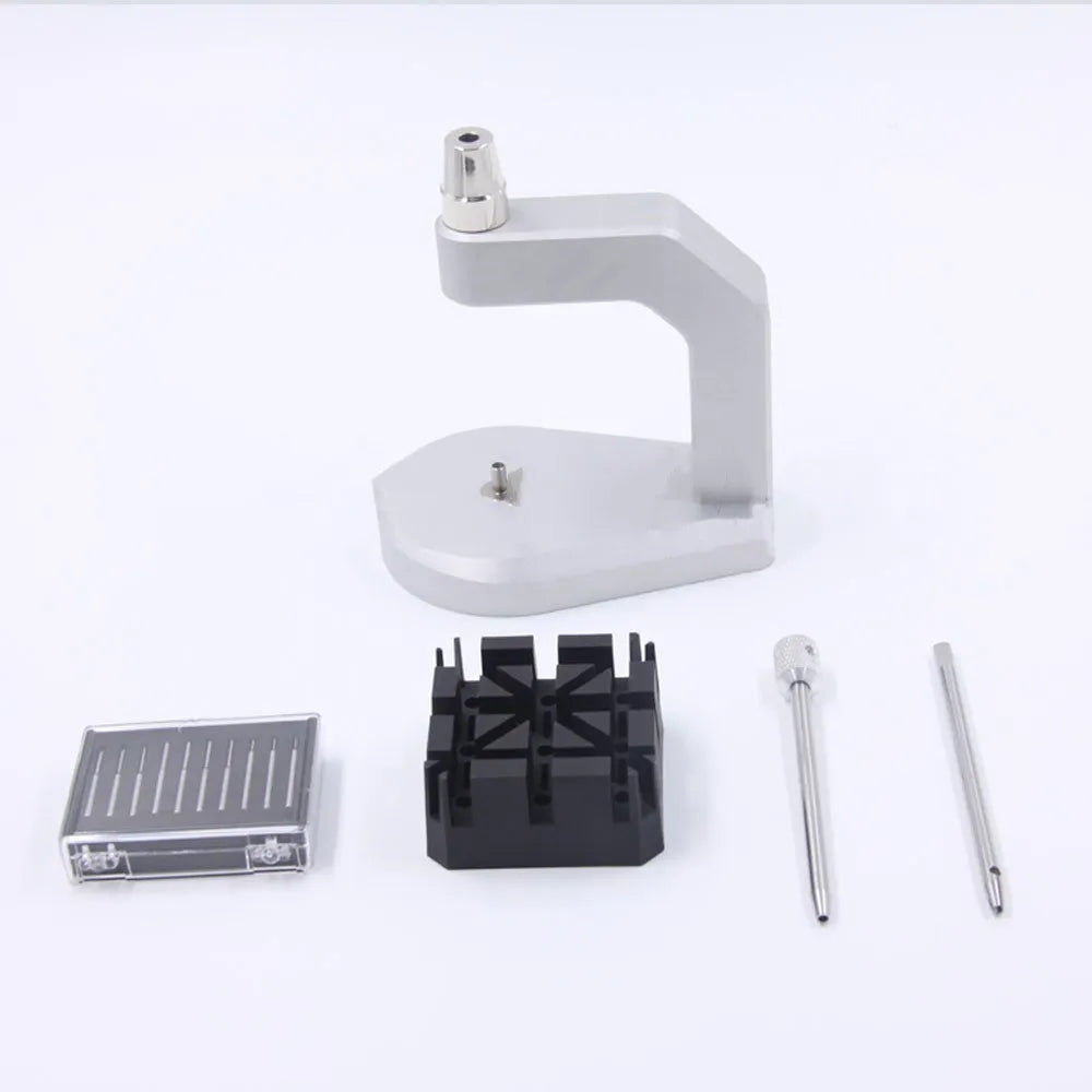 Silver tool steel multi-purpose press strap removal tool for watches and electronics on a workshop surface.