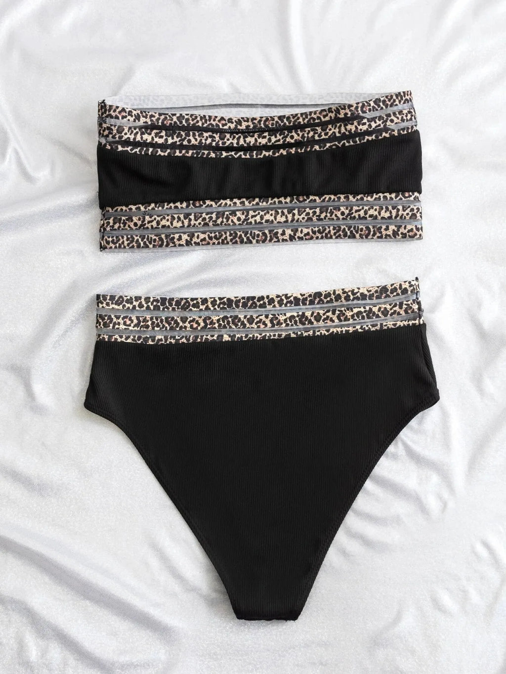Black strapless bikini top and shorts with leopard print detail, laid flat.