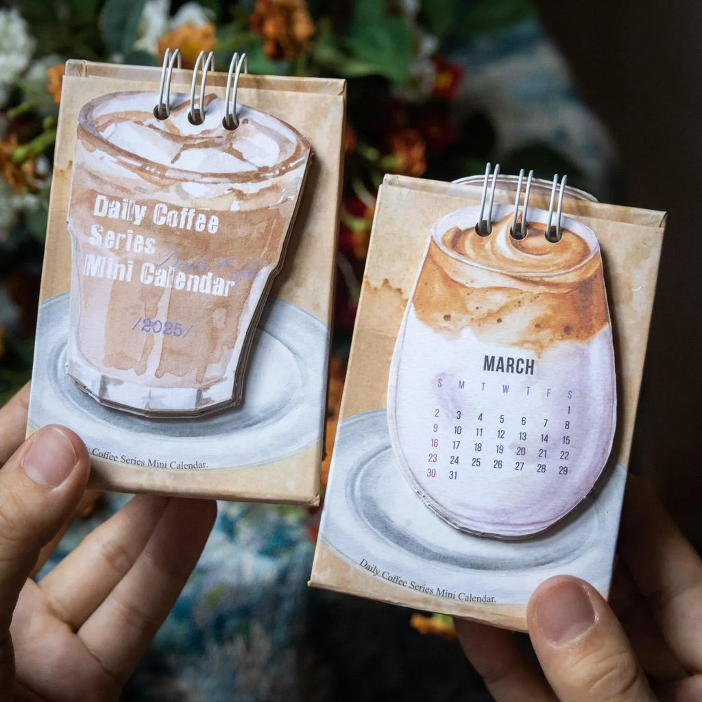 Mini A6 paper desk calendar for 2025 open to a monthly page with coffee-themed design.