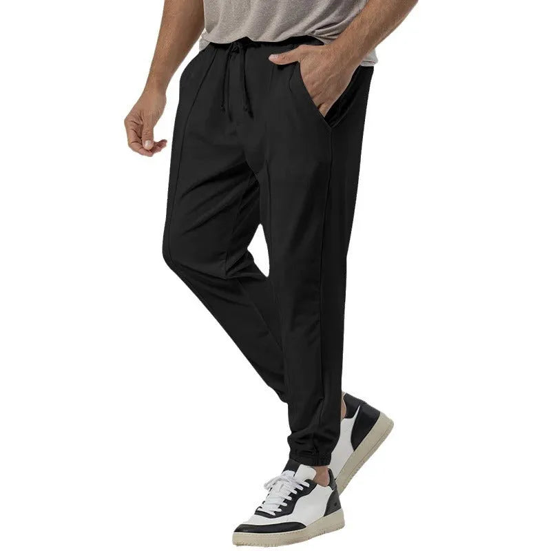 Men's grey casual track sweatpants with loose tapered cut and straight leg design, elastic waistband