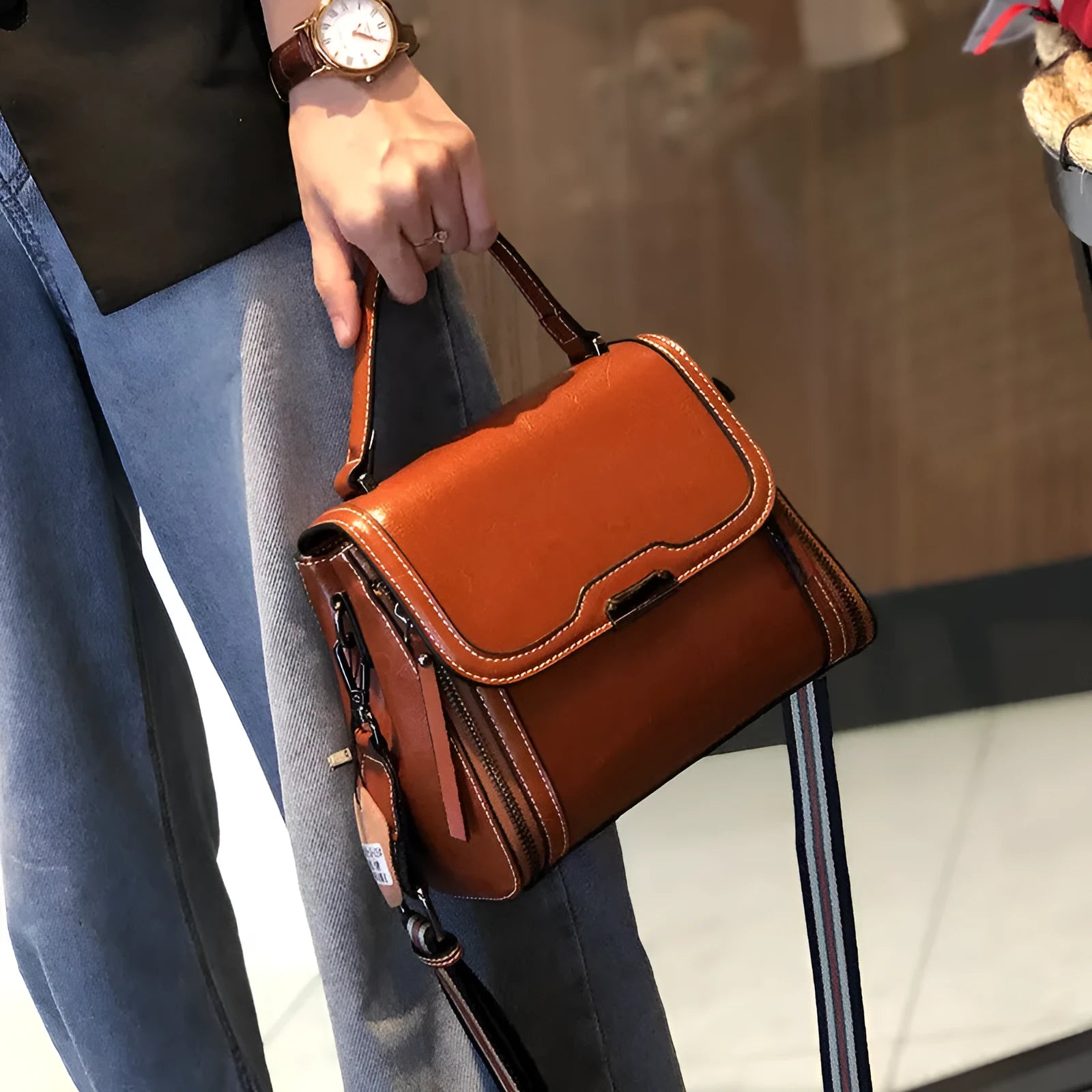 Women's brown genuine leather retro messenger bag with shoulder strap showing organised interior pockets.