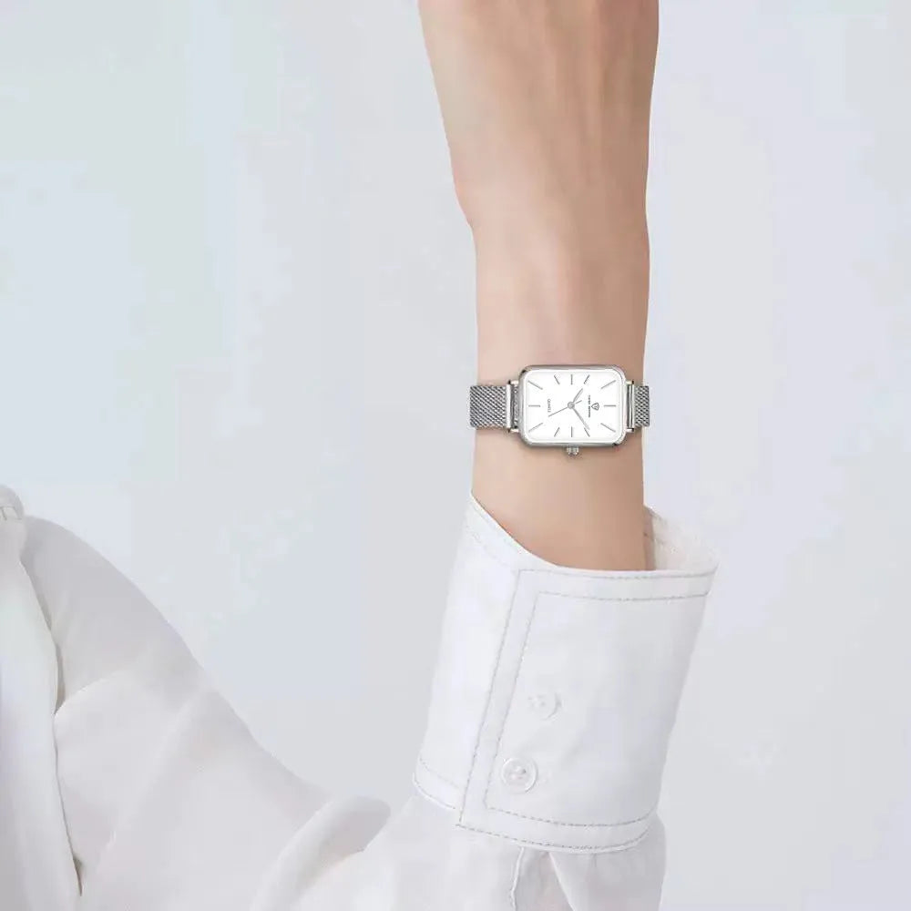 Women's rose gold waterproof quartz watch with woven steel band on wrist.