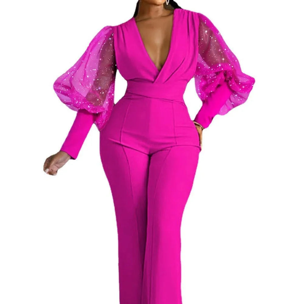 Red women's jumpsuit with mesh stitching on the torso, long sleeves, elastic waist, and wide-leg trousers.