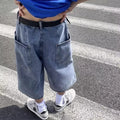 Man wearing blue washed denim pirate-style shorts with cropped length and high waist.