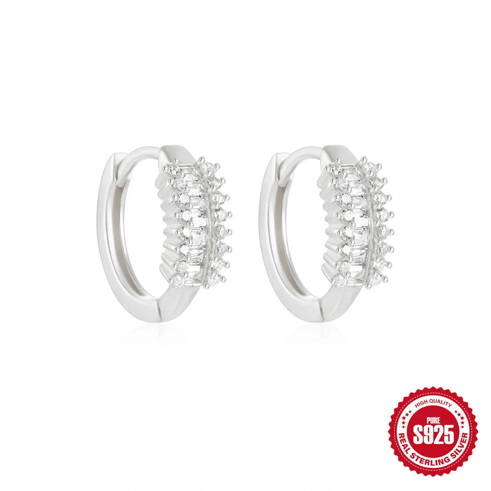 Sterling silver geometric stud earrings with a small round shape and classic diamond detail on a white background.