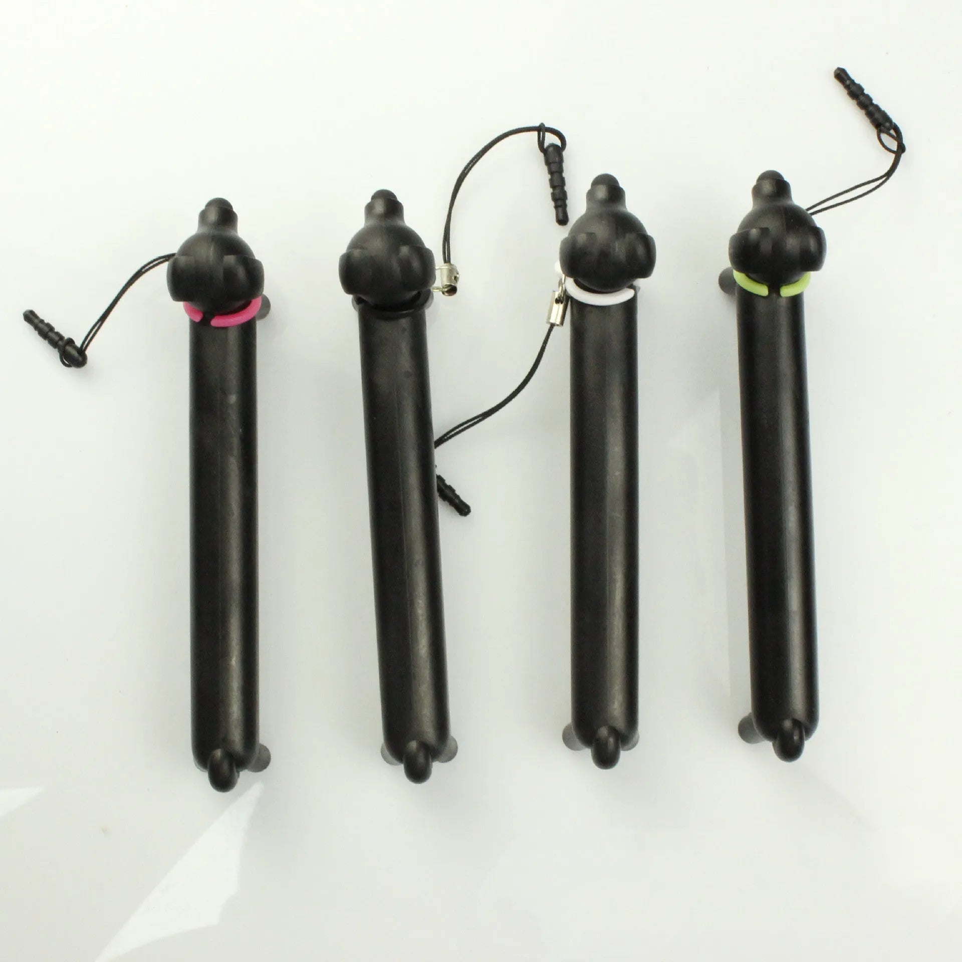 Black dog-shaped touch screen stylus with conductive body shown next to smartphone demonstrating phone holder function