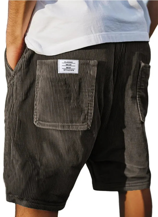 Men's grey corduroy shorts with multiple pockets and embroidery detail on leg, laid flat.