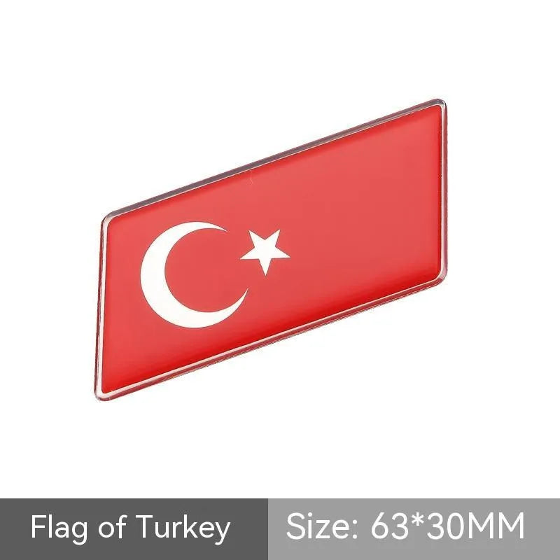 Aluminium metal car sticker with national flag design in a parallelogram shape.