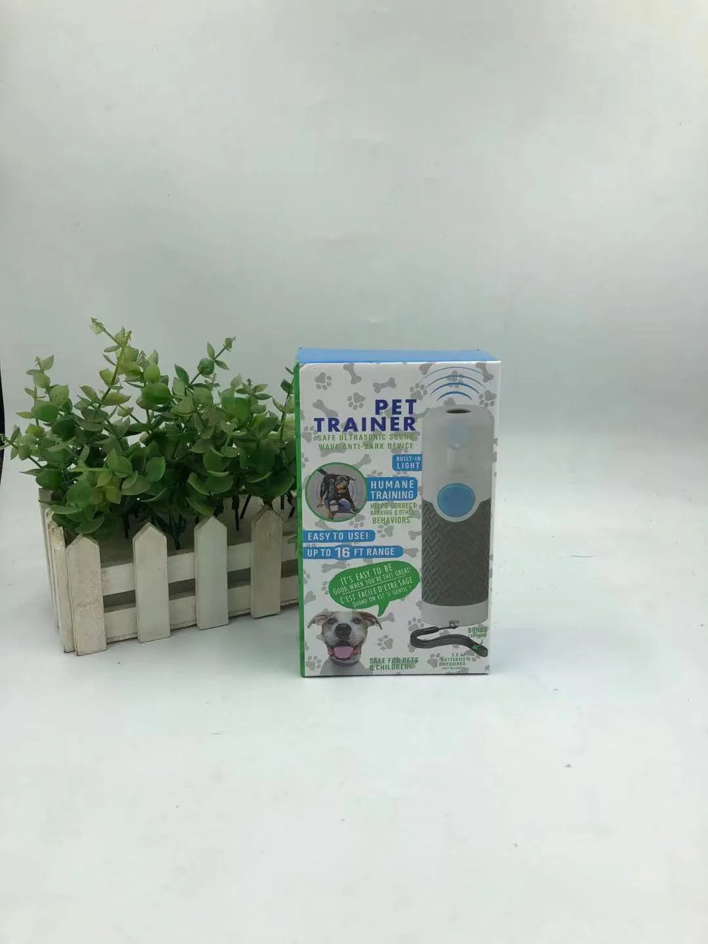 White handheld ultrasonic dog bark stop trainer on a plain background.